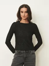 Top de manga larga en color negro, con cuello redondo y textura sutil en relieve con diseño floral.
