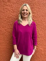 Sweater de hilo color fucsia, de corte holgado, con escote en V y mangas largas con vuelta.