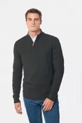 Buzo tejido de punto con textura, cuello alto y cierre frontal parcial. Presenta puños y ruedo acanalados, con un diseño clásico y versátil.