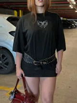 Remerón negro de corte oversize con moldería amplia y mangas cortas, confeccionado en algodón. Presenta un estampado frontal en el pecho con diseño de corazón de estilo gótico o tribal en color blanco.