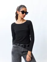 Remera negra de algodón, de manga larga y cuello redondo.