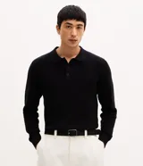 Suéter de punto texturizado color negro, con cuello polo, cierre frontal parcial con botones, manga larga y puños acanalados.