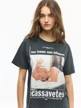 Remera negra de manga corta con cuello redondo, confeccionada en jersey de algodón, de calce regular y largo a la cadera, con estampa frontal inspirada en la película "Une femme sous influence".