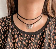 Gargantilla doble de cordón negro con dije de mariposa plateada.