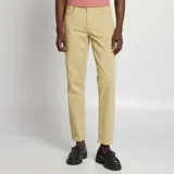 Pantalón chino de corte slim fit, color beige, con cinco bolsillos y cierre de botón y cremallera.