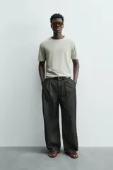 Camiseta de corte relajado (relaxed fit) color blanco roto o crema, con cuello redondo y manga corta.