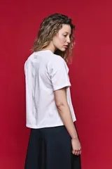Remera de algodón color blanco con diseño de tablas verticales en el frente que aportan movimiento y estructura.