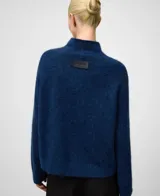 Sweater de punto en color tostado con cuello chimenea y mangas raglán, confeccionado en una mezcla de lana merino y alpaca que le otorga una textura suave y abrigada.