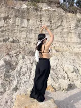 Pantalón negro de tiro alto, corte ancho y fluido, con cintura elástica.