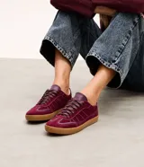 Championes estilo chutera color bordó, con recortes pespunteados, cordones con detalles contrastantes y suela de goma color caramelo.