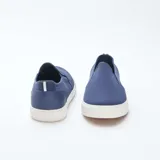 Zapatillas bajas sin cordones de malla azul con suela blanca.