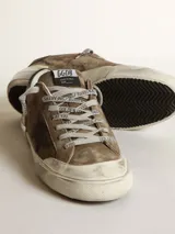 Zapatilla Super-Star de gamuza en color verde con acabado vintage, estrella lateral serigrafiada, contrafuerte de talón en cuero liso negro y suela multicapa con detalle metalizado plateado en el talón.