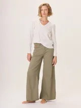 Pantalon de corte ancho y holgado, confeccionado en mezcla de algodón, viscosa y lino. Presenta costuras decorativas, pinzas debajo de la rodilla, bordado de monograma en el bolsillo delantero y pespuntes a contratono.