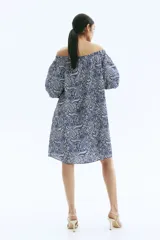 Vestido corto de manga globo, con escote amplio elástico y ajuste de tiras con cuentas en el centro del busto. Presenta un estampado paisley en tonos de azul.