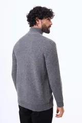 Buzo tejido de punto acanalado en color gris, con cuello alto y cierre frontal parcial. Presenta puños y ruedo elásticos.