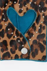 Mitones de cuero con estampado animal print y detalles en color turquesa. Presentan un recorte central en forma de corazón rodeado de pequeñas tachas metálicas y un cierre de broche a presión en la muñeca.