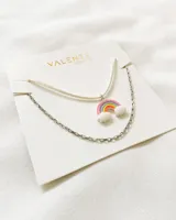 Set de dos collares con dije de arcoíris con nubes. Uno es de tiento blanco y el otro es de cadena plateada.