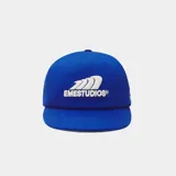Gorra azul marino con visera curva y cierre ajustable en la parte posterior. Cuenta con un escudo bordado en hilo blanco en la parte frontal con la inscripción "EMESTUDIOS".