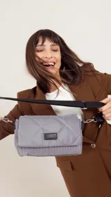 Bandolera capitoneada color bordó, con bolsillo interno, correa de galón ajustable y tapa con broche.