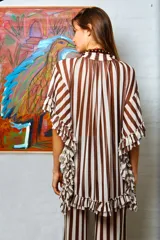 Camisola marrón con rayas verticales blancas, volados en las terminaciones y tajos laterales.