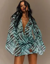 Vestido corto estampado con efecto animal print en tonos aqua y marrón, escote profundo en V cruzado y mangas largas anchas y acampanadas.