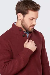 Buzo de punto color bordó, con cuello alto abotonado y detalle de cuero en el cuello.