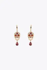 Pendientes de aro dorados con colgante en forma de calavera esmaltada con detalles florales en rojo y azul. Cuelga una joya engarzada con forma de gota de color rosa/fucsia.