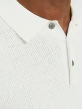 Polo de manga corta confeccionado en tejido de punto estructurado con textura sutil. Presenta cuello clásico, cierre frontal con tres botones y terminaciones en rib en mangas y ruedo.