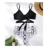 Conjunto de bikini de dos piezas de la marca Uniteduy, compuesto por un crop top amarillo liso con diseño cruzado y tirantes finos, y una bombacha de tiro alto con estampado floral y de hojas en tonos amarillos, verdes y blancos.