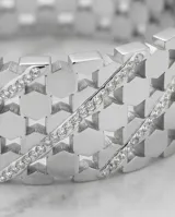 Esclava rígida de acero con diseño calado de círculos entrelazados y detalles de circonias engastadas.