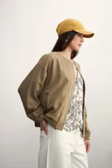 Chaqueta tipo bomber color negro, con cierre frontal metálico, cuello redondo y puños elásticos.