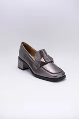 Mocasines plateados de cuero con aplique geométrico al tono y taco cuadrado.