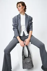 Cartera negra estilo hobo con apliques metálicos plateados en toda su superficie.