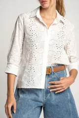 Camisa blanca de algodón con bordado calado tipo broderie, corte recto, cuello camisero y mangas 3/4.