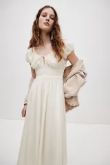 Vestido midi color blanco en tejido liviano, con escote redondo fruncido y abertura en V con tira fina ajustable en el frente. Tiene mangas cortas abullonadas, cintura elástica en punto smock y falda acamponada de corte midi.