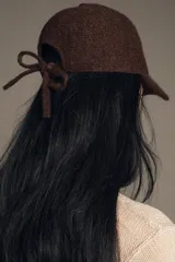 Gorra con visera confeccionada en tejido de punto con textura suave y acabado afelpado.