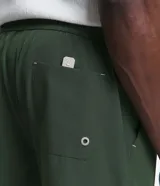 Bermuda masculina marca Marfinno de color verde militar, confeccionada en tejido plano de poliéster y elastano de secado rápido. Posee cintura elástica con cordón de ajuste y un bolsillo trasero.