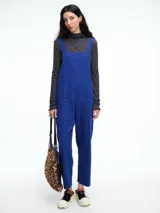 Mono largo de pana color verde oscuro, con breteles finos y silueta relajada de pierna amplia.