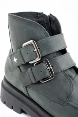 Bota corta de cuero lavado en tono gris oscuro, con suela track robusta y dos correas con hebillas metálicas en el lateral. Presenta un detalle de estrella metálica pequeña en la correa superior.