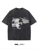 Remera negra de algodón con estampado frontal de una cara fantasmal en blanco y negro.