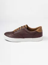 Champion de estilo urbano en color azul marino, con detalles en cuero sintético color suela en la lengüeta y el talón. Presenta perforaciones decorativas en los laterales y suela de goma blanca.