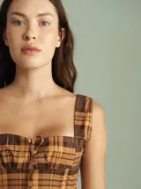 Vestido midi estilo corset con estampado a cuadros en tonos marrón y tostado, con breteles anchos y falda acampanada.