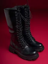 Bota de caña media color negro, con cordones y suela track.