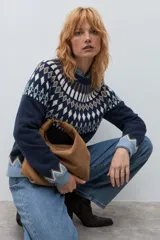 Sweater de punto en color azul marino con diseño jacquard geométrico en tonos blanco, marrón y verde en el canesú, puños y ruedo. Presenta cuello redondo y mangas largas.