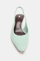 Zapato de tacón destalonado en ante color menta, con tira trasera elástica, tacón fino kitten y acabado en punta.