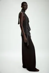 Top halter de viscosa con estampado de lunares, cuello halter, espalda descubierta y detalle de lazadas en el mismo tejido. Cuenta con bajo redondeado y cierre trasero con botones.