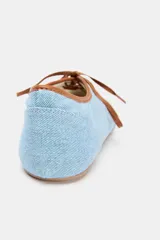 Bailarina celeste de tela denim con puntera redondeada, ribete marrón y lazo de ajuste marrón.