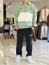 Pantalón de jogging oversize negro con felpa, de corte recto y cordón ajustable en la cintura. Presenta un pequeño estampado de texto blanco en el lateral izquierdo.