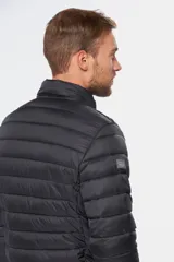Campera capitoneada de nylon color negro, con relleno de guata siliconada, capucha integrada, bolsillos con cierre y cierre frontal.