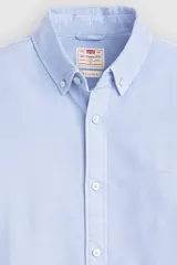 Camisa celeste de manga larga con cuello abotonado y cierre frontal de botones. Confeccionada en algodón con sutil bordado en el pecho.